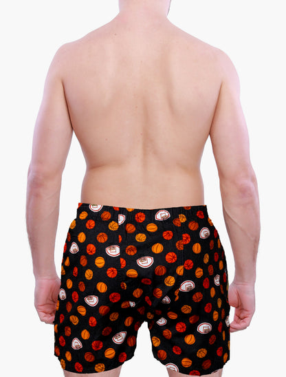 Back side of a Person wearing black swim shorts with red and orange basketball graphics on a white background