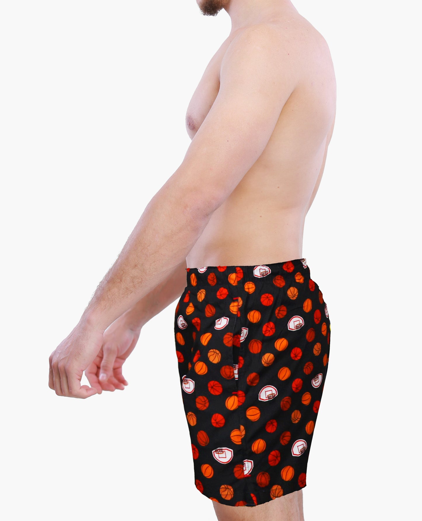 Person wearing a black boxer shorts with red and orange basketball graphics on a white background