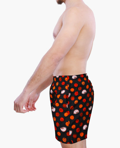 Person wearing a black boxer shorts with red and orange basketball graphics on a white background