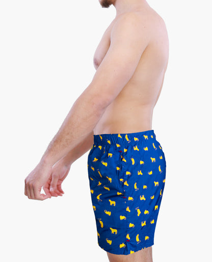 Side view of a male model wearing blue boxer shorts with yellow cats graphics on a white background