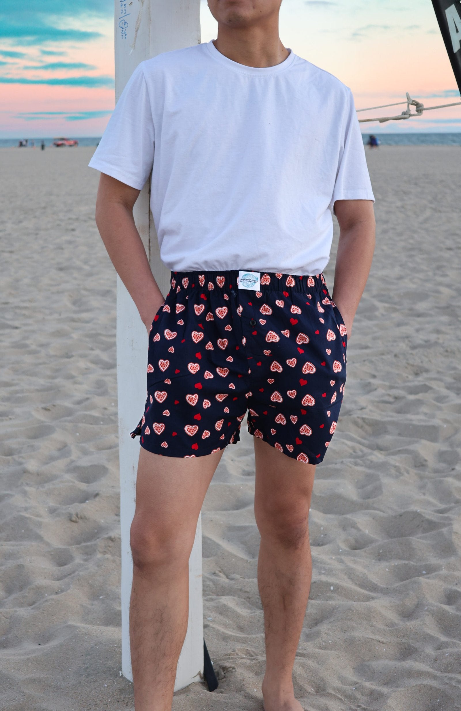 Front side of Male Model in Weunderlust Woven Cotton Boxers with pockets at the beach, Sweethearts, Navy, Hearts printing