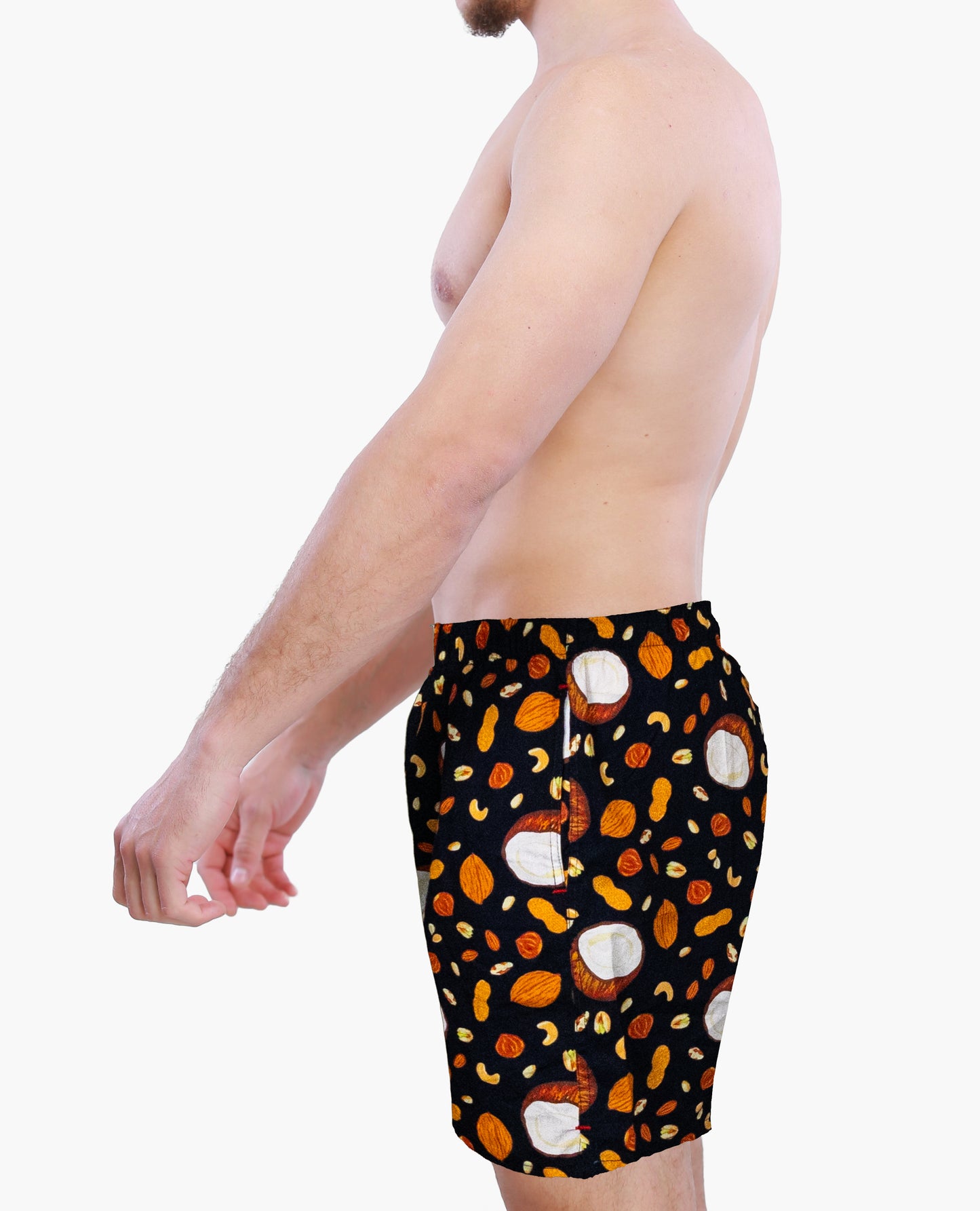 Side view of a male model wearing Weunderlust boxer Shorts with a pattern of coconut and nuts on a white background