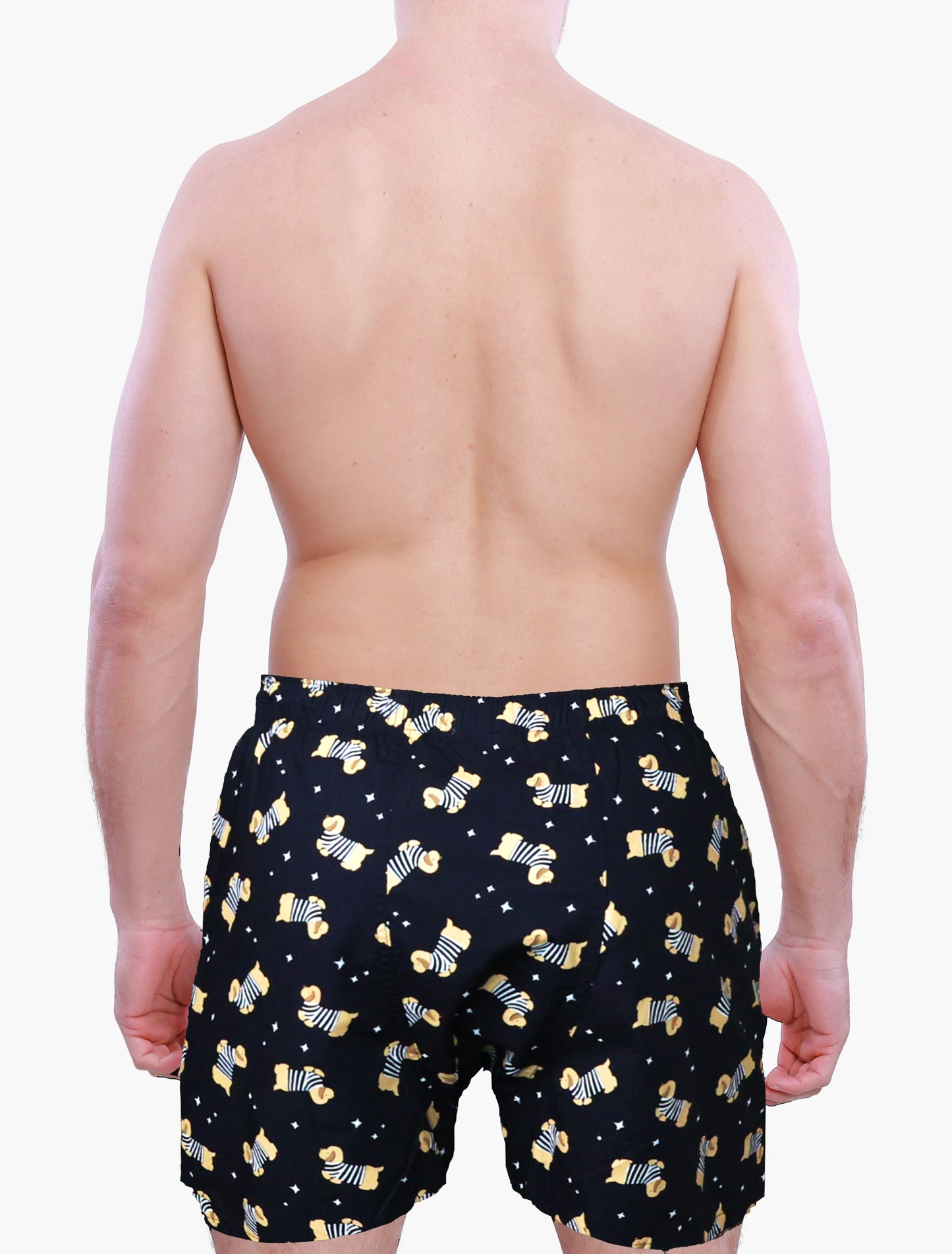 Person wearing black boxer shorts with yellow dog pattern on a white background