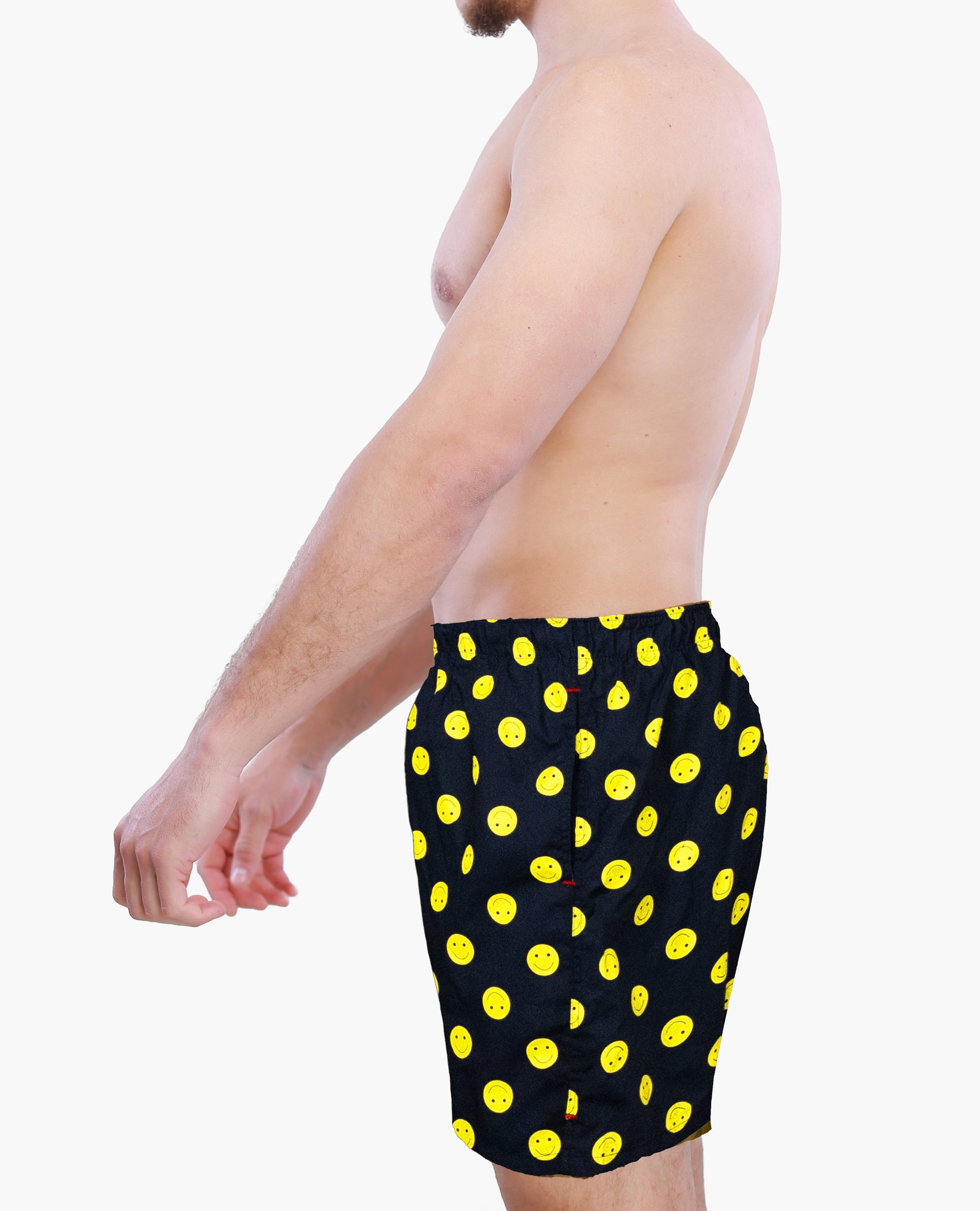 Person wearing black boxer shorts with yellow smiley icons on a white background