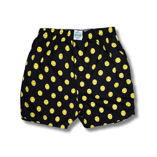 Black boxer shorts with yellow smiley face pattern on a white background