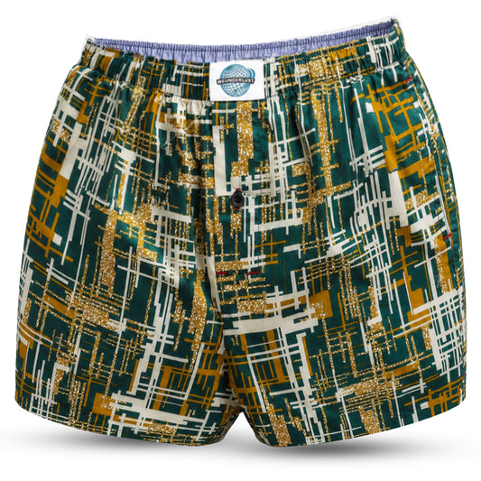A pair of men's woven cotton boxer shorts with a geometric pattern featuring green, yellow, and blue colors, and a brand tag visible on the waistband.