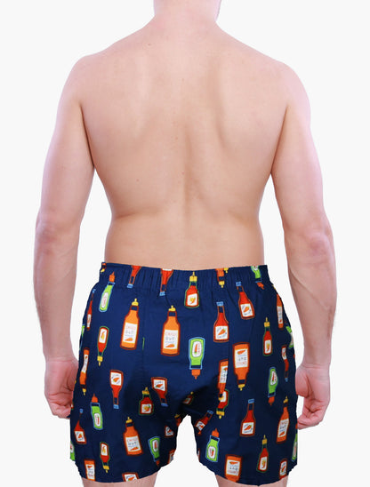 back side of a male model wearing Weunderlust Navy blue boxer shorts  with hot sauce bottle pattern on a white background